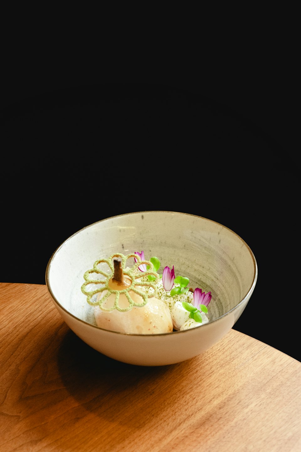 Dessert gourmet di pere con pizzo commestibile e microgreens.